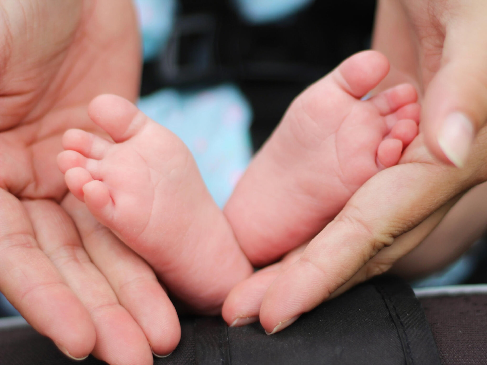 Parents holding a newborn baby's feet